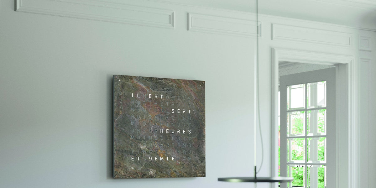 Horloge QLOCKTWO Earth 45 en marbre brun affichant « il est sept heures et demie » en toutes lettres