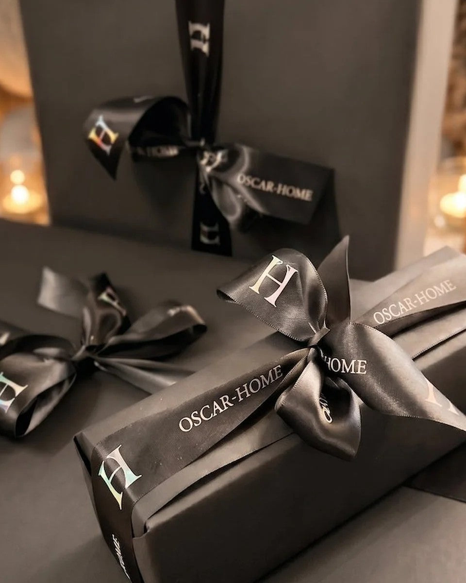 Paquets cadeaux Oscar-Home noirs fermés d'un ruban siglé