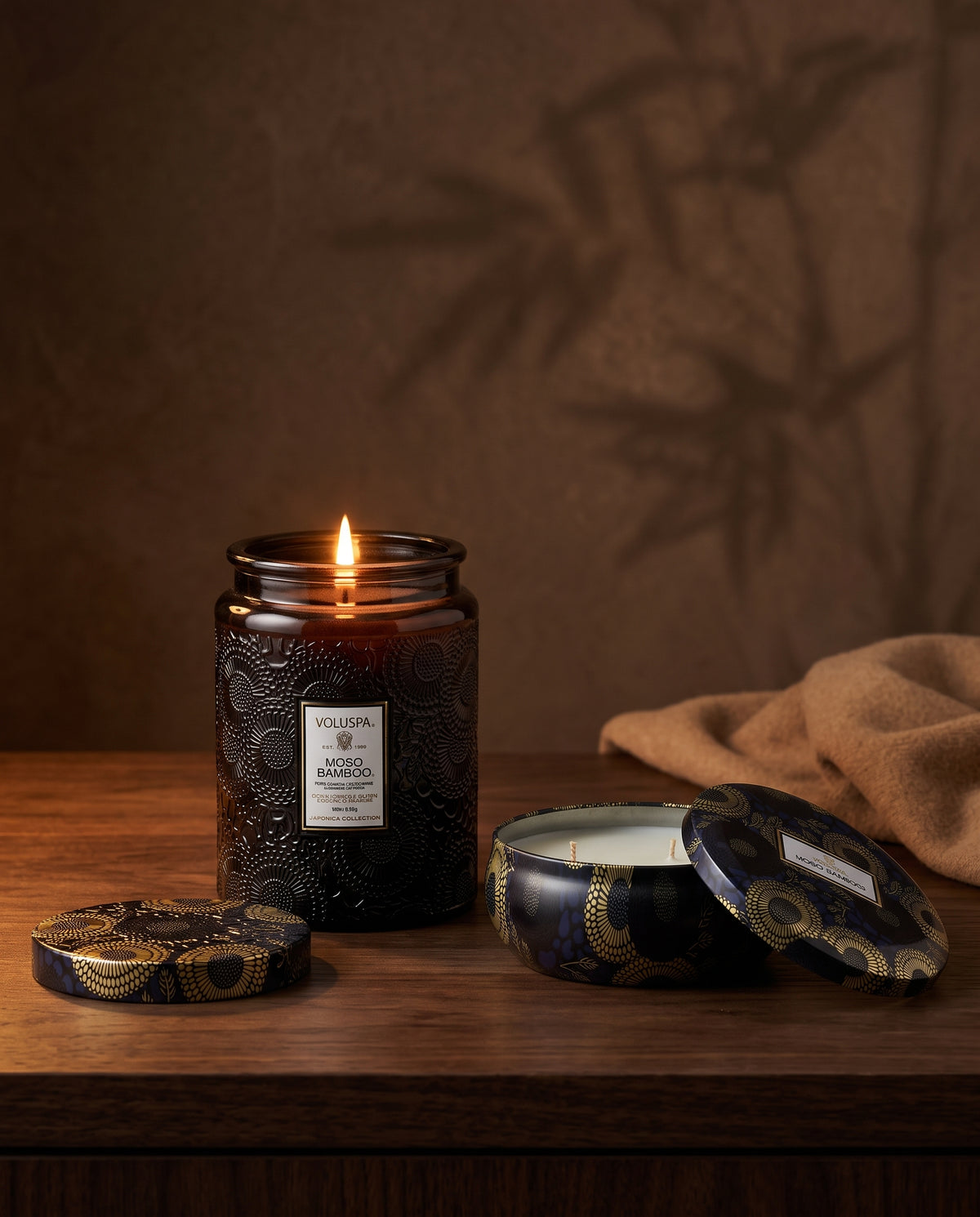 Bougies Voluspa Moso Bamboo, pot en verre Japonica et boîte métal, sur une table en bois